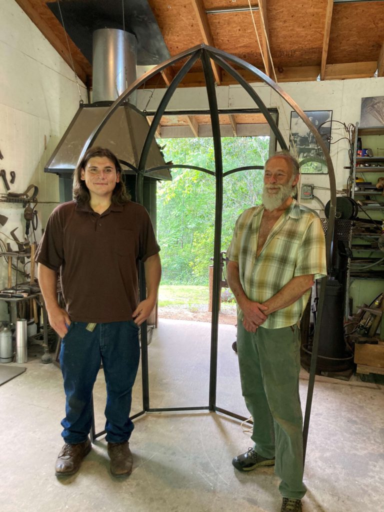 Sculptors Nathan Wachacha David Bush and William Rogers stand in front of their sculpture in progress.